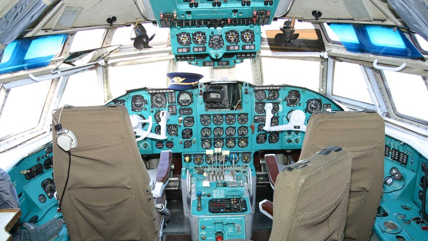 A wide view shows the cockpit and controls of a Ilyushin Il-62 plane.