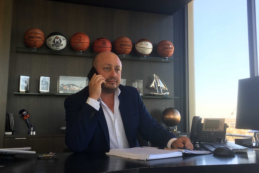 Larry Kestelman sits on phone at desk.