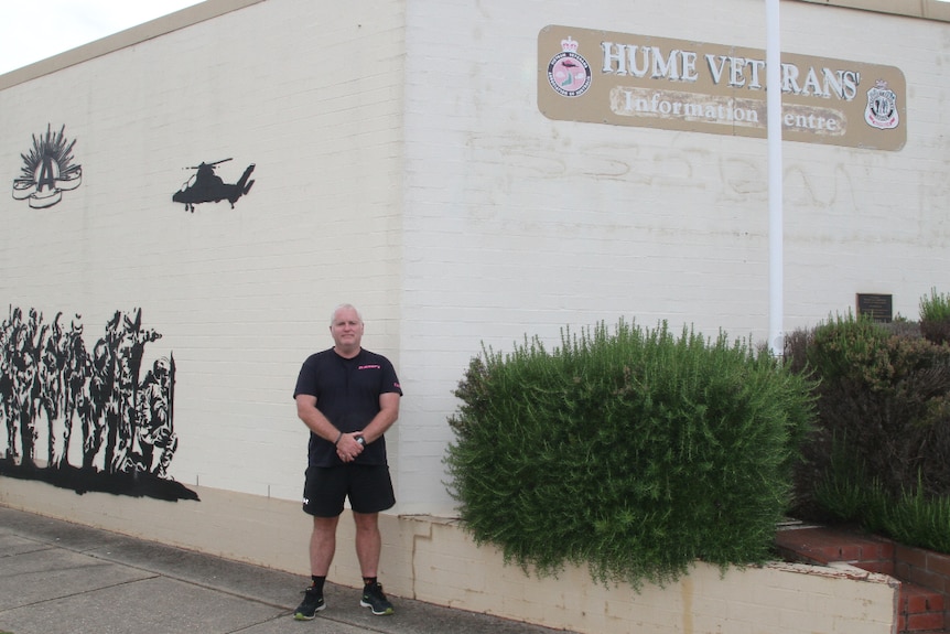 Hume Veterans' Information Centre Secretary Jason Sofield stands in front of the aging beige Wodonga building they're based in.