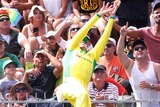 Steve Smith leaps backwards and grabs the ball close to the boundary line. The crowd looks on in suspense.