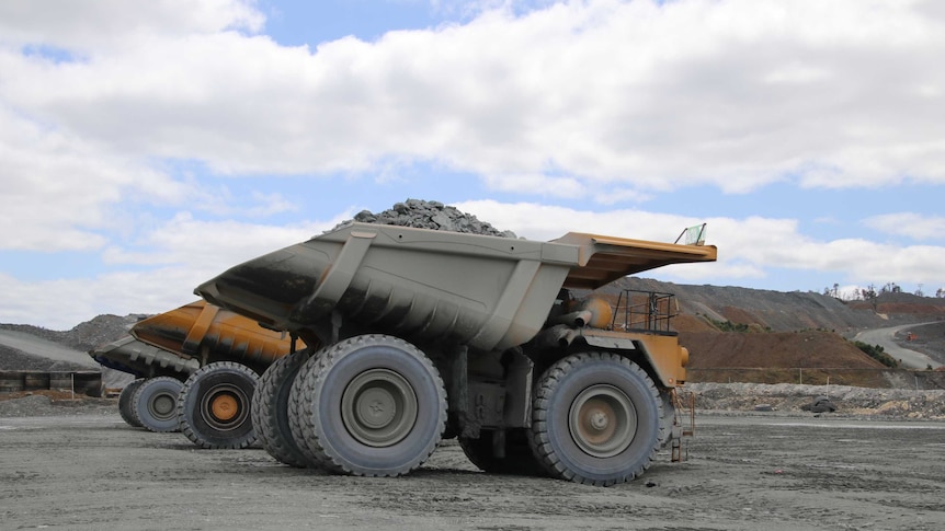 Several mining dump trucks lined up.