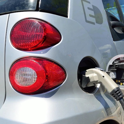 A close-up photo of an electric vehicle charging at a port. 