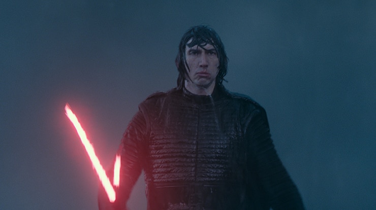 A man with serious expression, drenched dark hair wears black outfit and holds red lightsaber.
