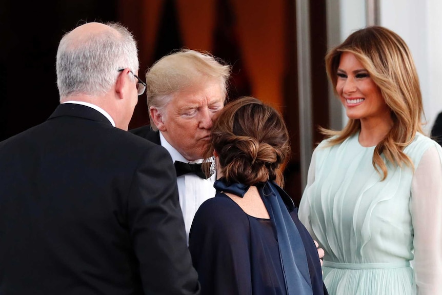 Donald Trump kisses Jenny Morrison on the cheek as Melania Trump and Scott Morrison look on.