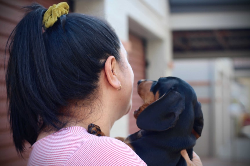 Dee looks away from the camera so you can only see the back of her head and her dog.