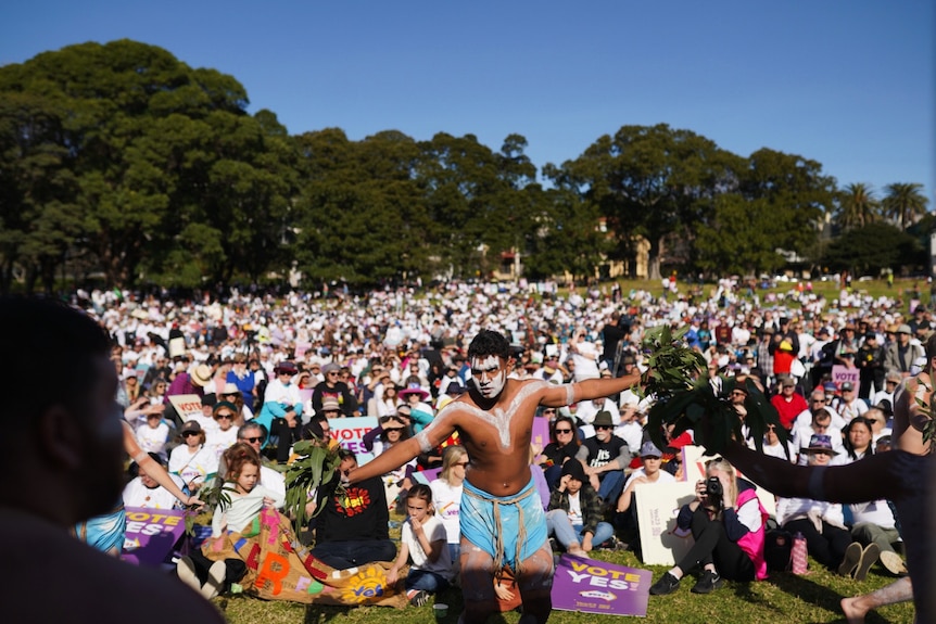 Indigenous dancers perform for a crowd at the Come Together For Yes rally in Sydney's Prince Alfred Park
