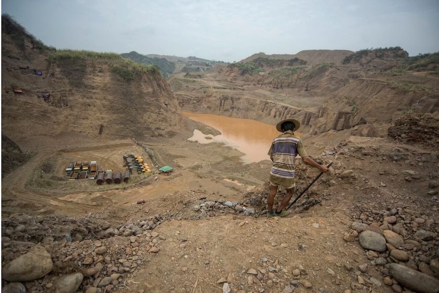 A jade mine worker digs up the ground in Myanmar