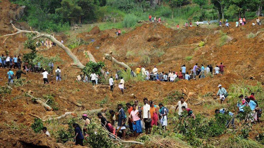 Residents search at the site of a landslide in central Sri Lanka