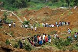 Residents search at the site of a landslide in central Sri Lanka