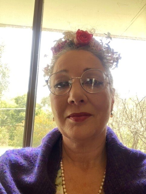 Sarah Triffitt smiles for a selfie. She's wearing glasses and a purple jacket.