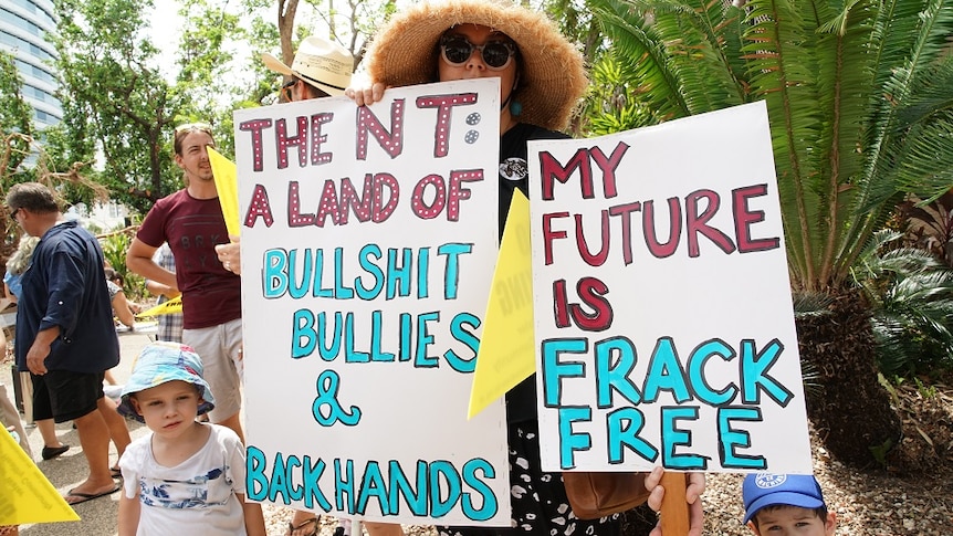 A placard says "The NT: A land of bullshit, bullies & backhands"; another says "My future is frack free"
