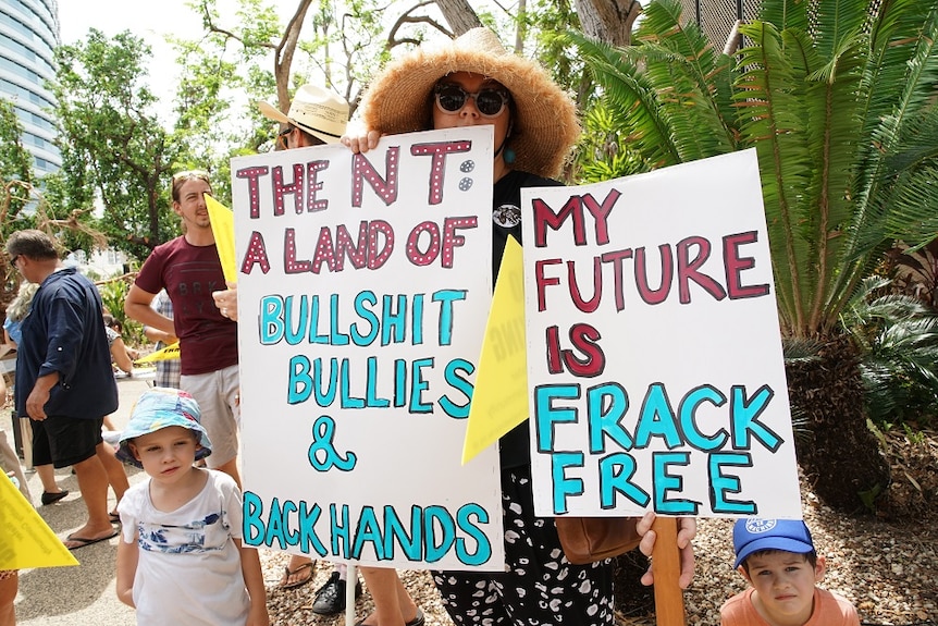 A placard says "The NT: A land of bullshit, bullies & backhands"; another says "My future is frack free"