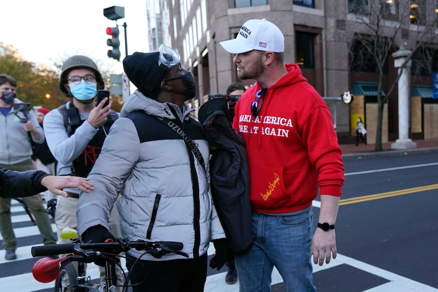 A Supporter of President Donald Trump confronts a counter-protester in the middle of the street.