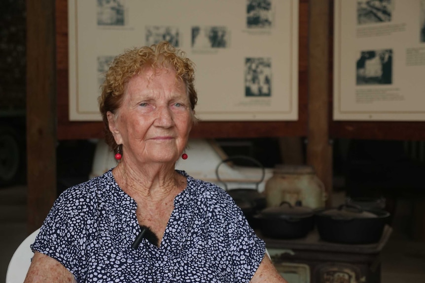 Neila Boyle is sitting in front of a historical display showing old photos in the Katherine Museum.