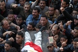 Egyptian demonstrators carry the body of a dead comrade wrapped in the Egyptian flag