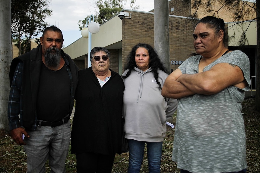 A family standing outside a court house.