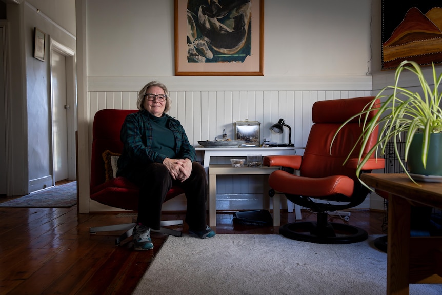 Christine Thirkell sitting on a chair in her living room. 