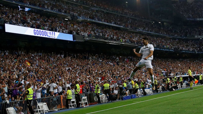 Marco Asensio leaps in the air after scoring for Real Madrid.