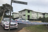 Police cars and police tape outside a unit block where a woman was found stabbed.