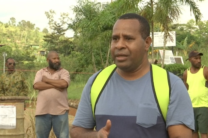 James Enage speaking at the Owers Corner on the Kokoda Track wearing a high–vis