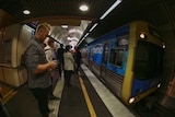 A commuter waits for a train in Melbourne's rail loop