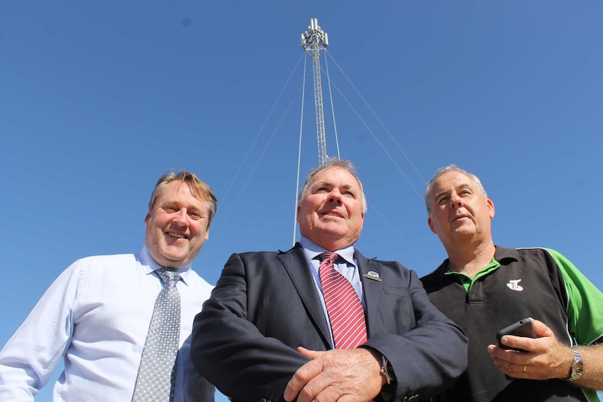 Kulin Shire president Barry West with O'Connor MP Rick Wilson and Telstra's Boyd Brown in front of a mobile phone tower.