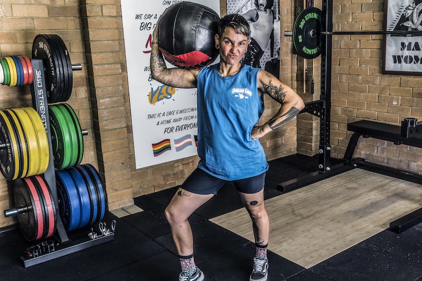 Elsie El-Asamar poses for a photo with a medicine ball on her shoulder, at Pony Club Gym in Melbourne.