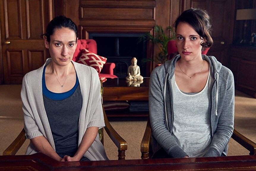Sian Clifford and Phoebe Waller-Bridge sit facing the camera in a scene from Fleabag.