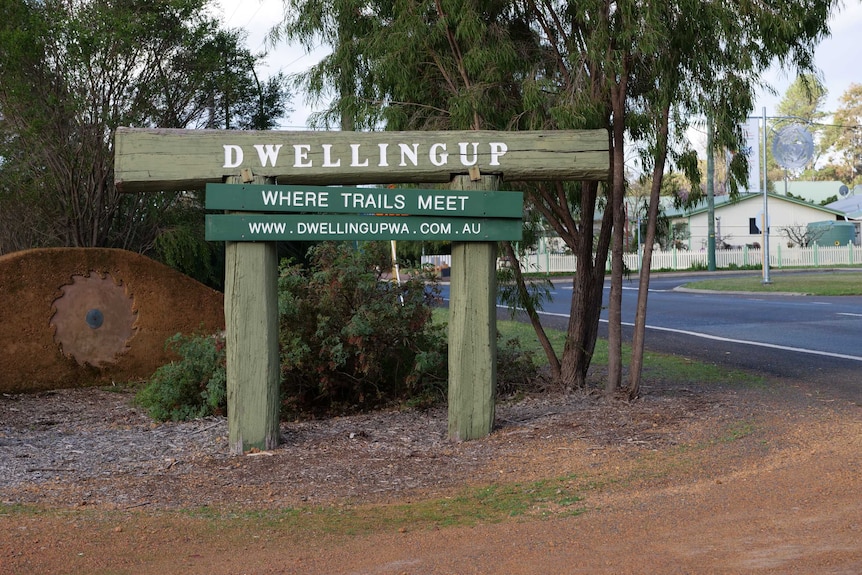 A sign near a road saying 'Dwellingup- where trails meet'.