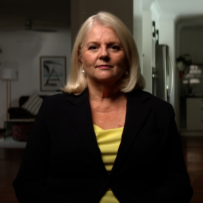 Karen Andrews sits in a room, looking into camera with a serious expression.