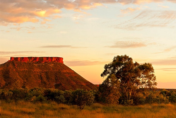 Two rocky outcrops appear with the sun low in the sky