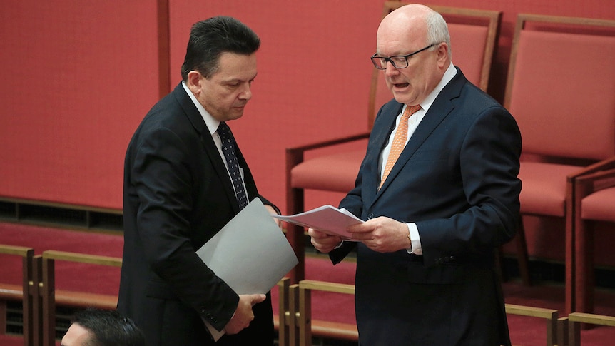 Nick Xenophon talks with George Brandis in the Senate.