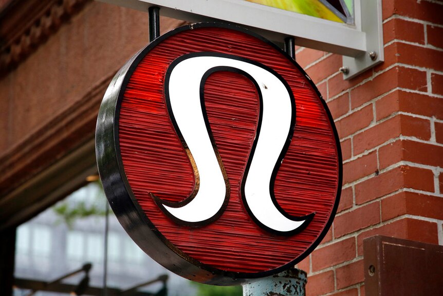 A Lululemon logo on a sign outside a store.