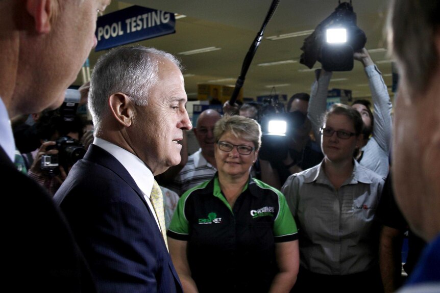 Malcolm Turnbull speaks with Mitre 10 workers while surrounded by media.