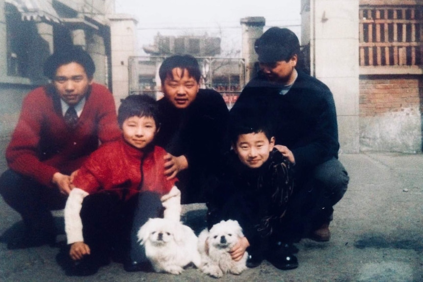 Bang and his four cousins looking at the camera with two white peking dogs - Duo Duo and her daughter Dou Dou.