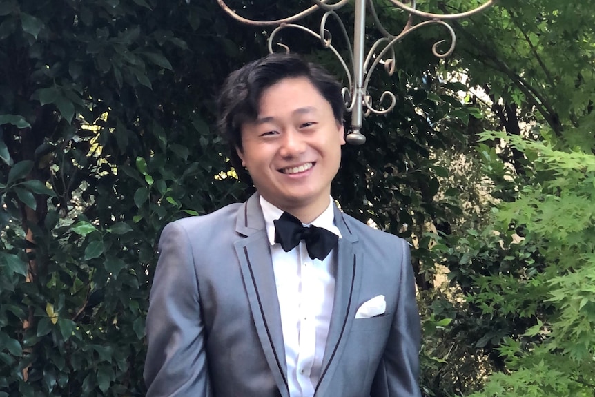 Photo of smiling Asian man wearing a tuxedo