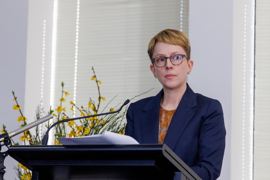 A woman standing at a lectern.