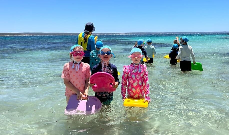 Children at beach swimming lesson