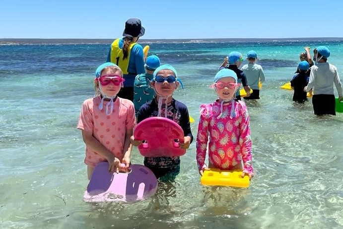 Children at beach swimming lesson