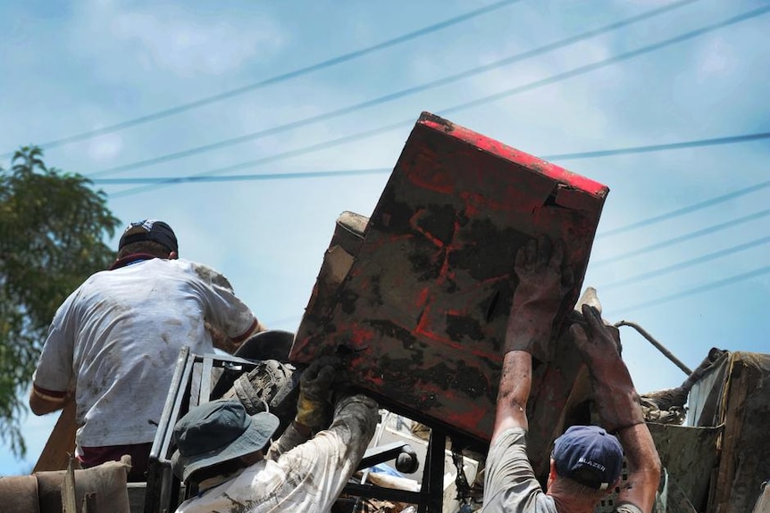 Volunteers help lift furniture during flood clean-up in St Lucia