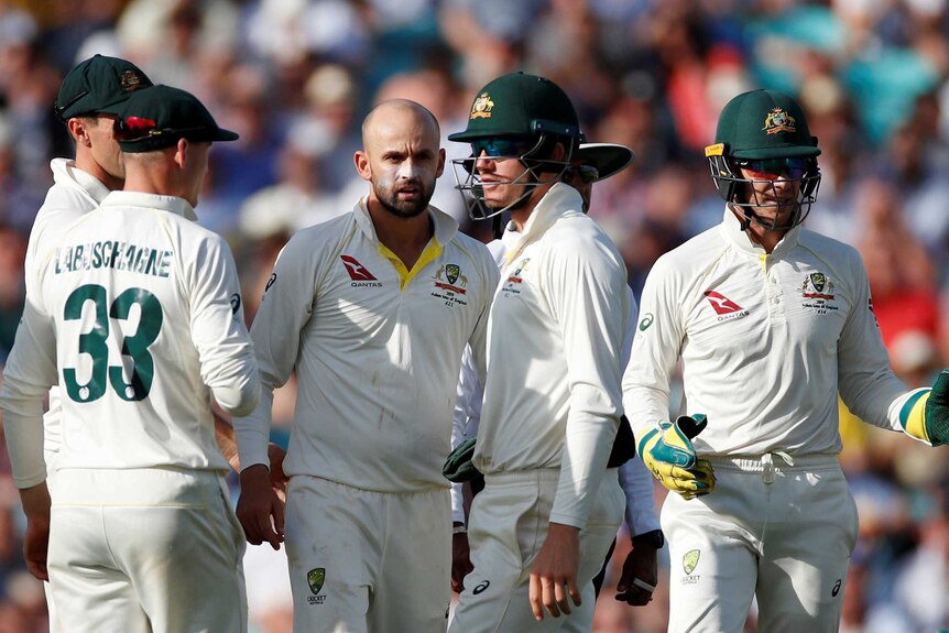 Members of the Australian men's cricket team stand on the field during a Test against England.