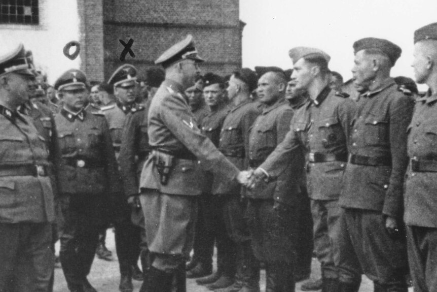 Heinrich Himmler (Centre left) shakes hands with new recruits at the Trawniki concentration camp.
