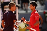Serbia's Novak Djokovic (R) shakes hands with Croatia's Borna Coric after win at Madrid Open.