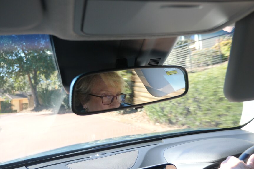 Woman's reflection in the rearview mirror