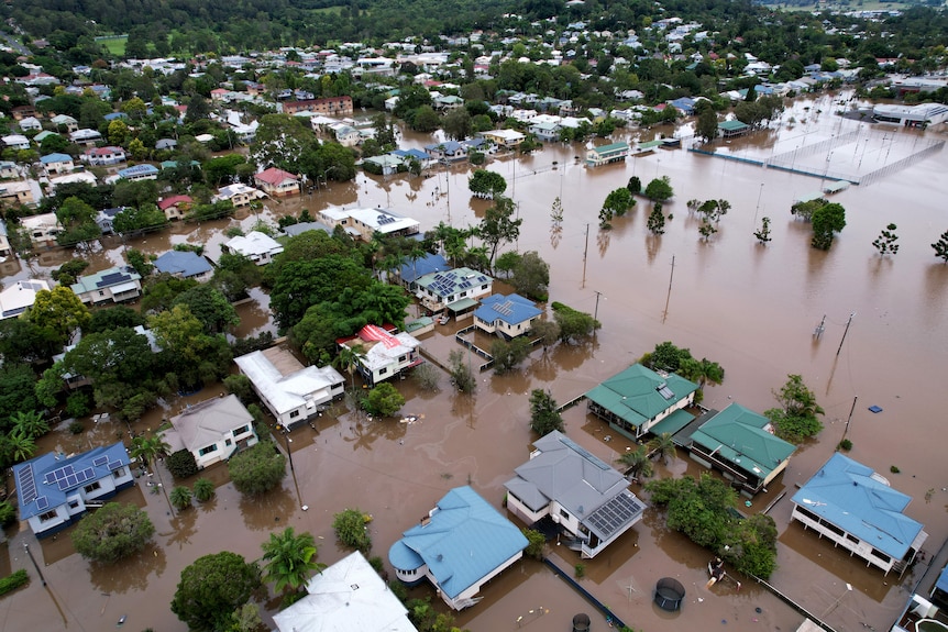 Streets and houses shown flooded in an aerial shot.
