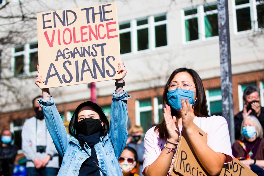 Two women of Asian descent in face masks at a protest