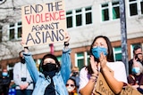 Two women of Asian descent in face masks at a protest