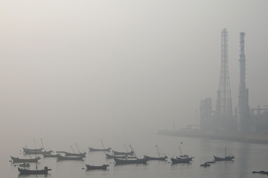 Boats in a bay in China, shrouded in haze from smog.