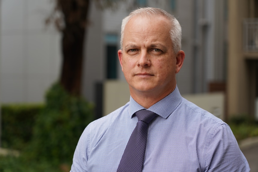 A close-up of Matthew Jarman wearing a shirt and tie.