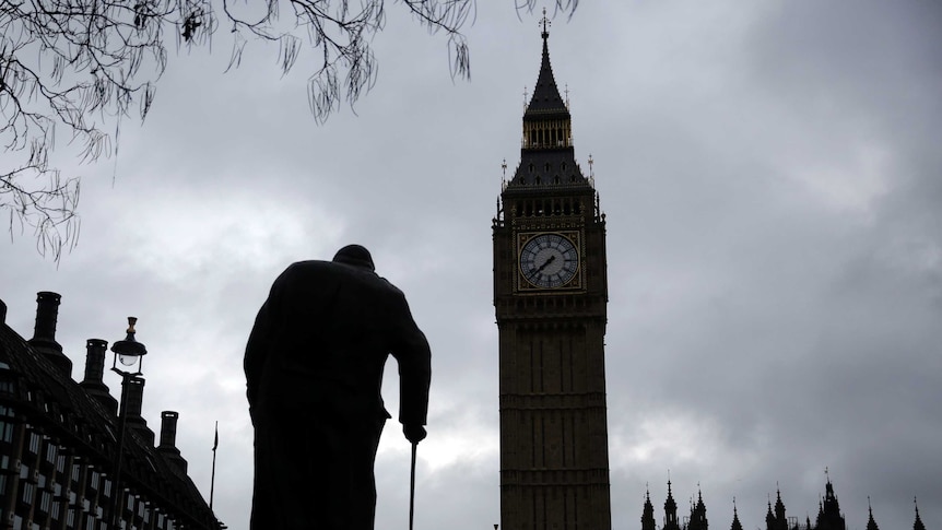 A statue of Winston Churchill in front of the Houses of Parliament in London.